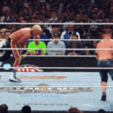a man in a green shirt is standing in a boxing ring