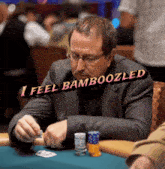 a man sits at a poker table with a sign that says i feel bambooozled