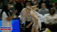 a basketball game is being played with a brennan sign in the background