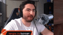 a man with a beard wearing headphones and a microphone .