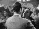 a man and woman are dancing together in a crowded room