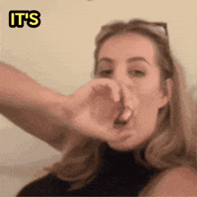 a woman covering her nose with her hand with the words it 's written above her