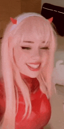 a close up of a woman wearing a pink wig and a red outfit .