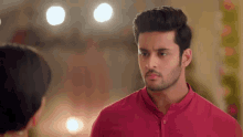 a man in a red shirt is looking at a woman in a black dress .