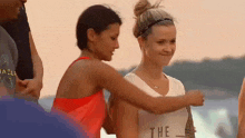 a woman wearing a white tank top that says the on it