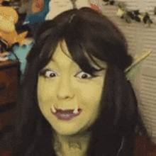 a woman is wearing a wig and making a funny face with her mouth open .