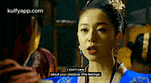 a woman in a blue and gold dress says i don 't care about your precious little feelings .