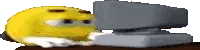a yellow smiley face is laying on top of a stapler on a table .