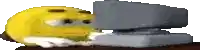 a yellow smiley face is laying on top of a stapler on a table .