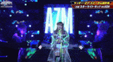a woman stands in front of a stage with azm written on it