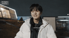 a man wearing a white jacket with the kingdom glamping written on the bottom right