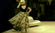 a woman in a polka dot dress is standing on a stage .