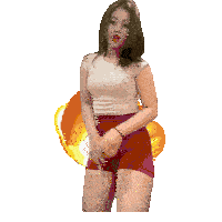 a woman in a white shirt and red shorts stands in front of a large explosion
