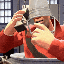 a man with a bucket on his head is talking on a cell phone