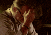 a man with glasses is drinking a cup of coffee in a dark room