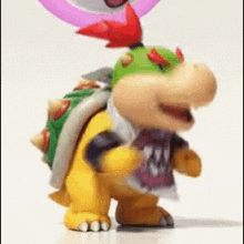 a cartoon character is standing on a white surface with a pink balloon behind him