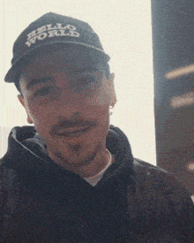 a man wearing a black hello world hat