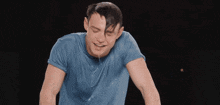 a man in a blue shirt is sweating and smiling