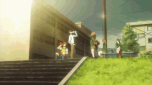 a group of people standing in front of a building with the sun shining through the fence