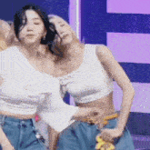 two women are standing next to each other on a stage .
