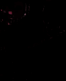 a man playing a guitar in a dark room with a sign that says cueva del bosque in the background