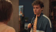 a man in a blue and white jacket is smiling at a woman
