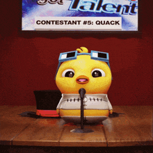 a contestant # 5 quack is sitting at a table with a microphone