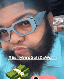 a man with a beard wearing glasses has a stack of money in front of his face