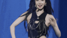 a woman with long black hair is wearing a black top with chains around her neck
