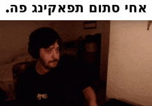 a man with a beard is sitting in front of a computer screen with a foreign language caption