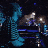 a man in a striped shirt is playing a keyboard in front of a sign that says se7
