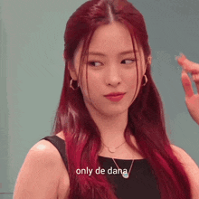 a woman with red hair is wearing a black dress and a necklace and says only de dana .