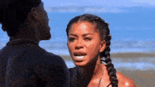 a man and woman are looking at each other on the beach