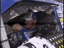 a man sitting in a race car with the number 48 on his hat