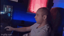 a man sitting in a chair using a computer mouse .