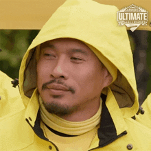 a man wearing a yellow jacket with a hood and a canada 's ultimate challenge logo