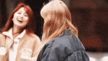 two women are laughing and one has a jacket that says ' a ' on it