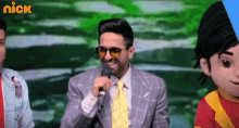 a man in a suit and tie is holding a microphone and smiling
