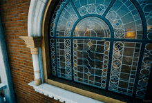 a stained glass window on a brick building with the name kepler on the bottom