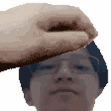 a pixelated image of a person 's head with a hand on it
