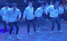 a group of men are dancing on a stage