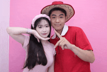 a man in a red shirt and a woman in a pink headband pose for a photo