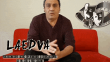 a man sits on a red couch with the name laedva written on the bottom