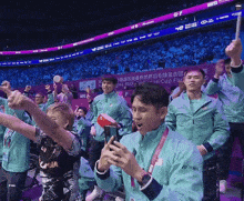 a group of people cheering in front of a sign that says asian cup final