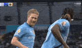 two soccer players are celebrating a goal during a match