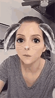 a woman is wearing bunny ears on her face .