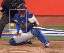 a baseball player in a blue uniform is kneeling on the base .