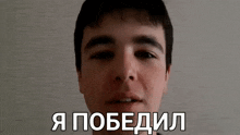 a close up of a young man 's face with the words i won in russian on the bottom .