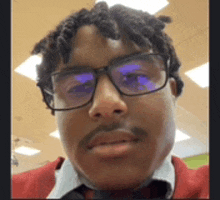 a close up of a man wearing glasses and a red jacket