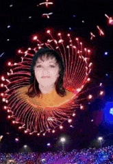 a woman 's face is surrounded by fireworks and lights